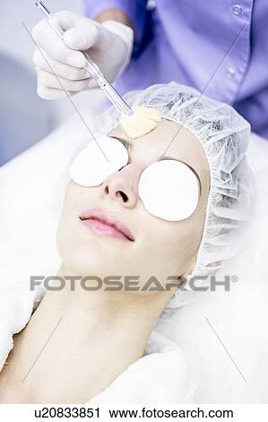 Stock Image - Dermatologist cleaning face after microdermabrasion treatment in clinic, close-up.. Fotosearch