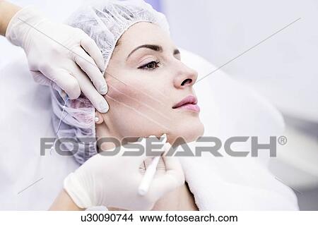 Dermatologist drawing marks on woman face for thread-lift, close-up. View Large Photo Image Picture - Dermatologist drawing marks on woman face for thread-lift, close-up.. Fotosearch