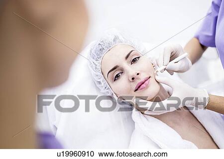 Stock Image - Dermatologist drawing marks on woman face for thread-lift, close-up.. Fotosearch