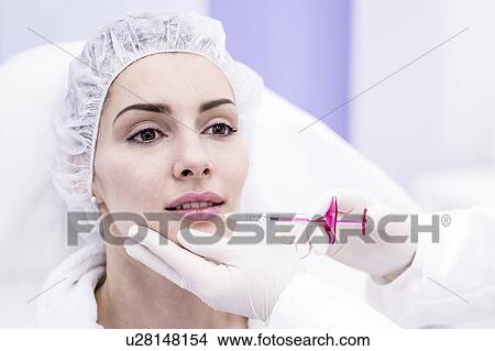 Dermatologist injecting botox into a woman's lips, close-up. View Large Photo Image Picture - Dermatologist injecting botox into a woman's lips, close-up.. Fotosearch