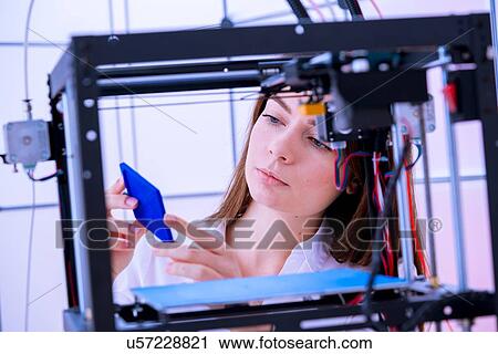 Stock Image - Designer working with 3D printer.. Fotosearch