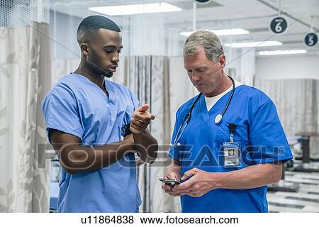 Stock Photo - Doctor and nurse using smart phone in hospital. Fotosearch