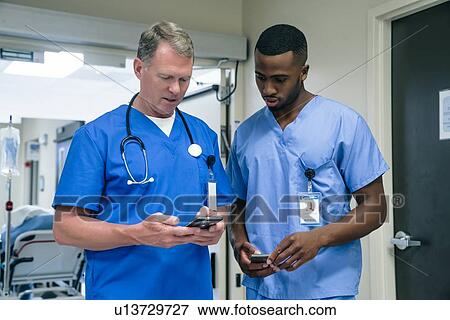 Stock Photo - Doctor and nurse using smart phone in hospital. Fotosearch