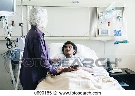 Stock Image - Doctor comforting teenage patient. Fotosearch