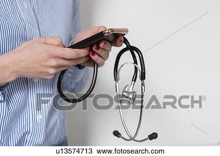 Doctor holding stethoscope and smart phone View Large Photo Image Stock Image - Doctor holding stethoscope and smart phone. Fotosearch