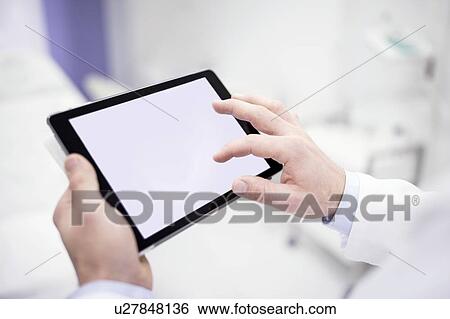Stock Photograph - Doctor using digital tablet, close-up.. Fotosearch