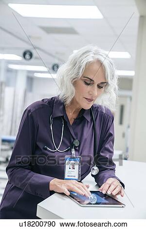 Stock Image - Doctor using digital tablet in hospital. Fotosearch