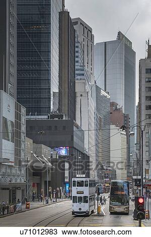 Stock Image - Double-decker tram and bus on street in Hong Kong, China. Fotosearch