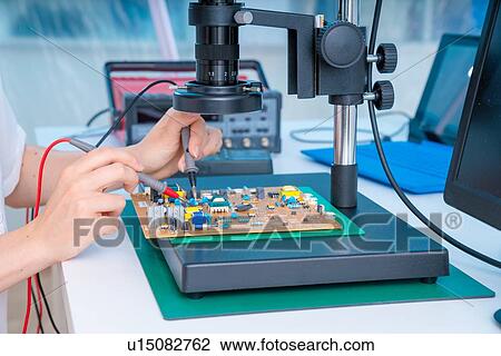Stock Image - Engineer working on circuit board.. Fotosearch