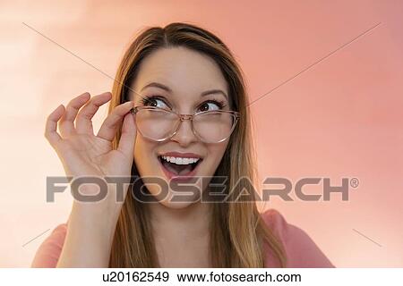 Stock Photo - Excited young woman wearing glasses. Fotosearch