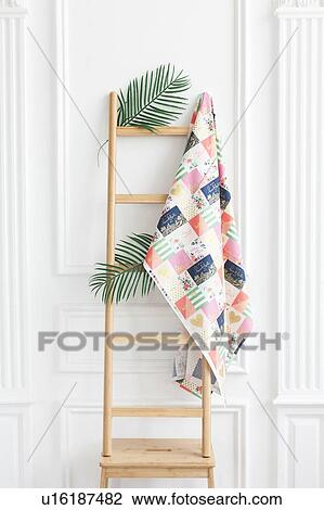 Stock Image - Fabric on rack with palm leaves. Fotosearch