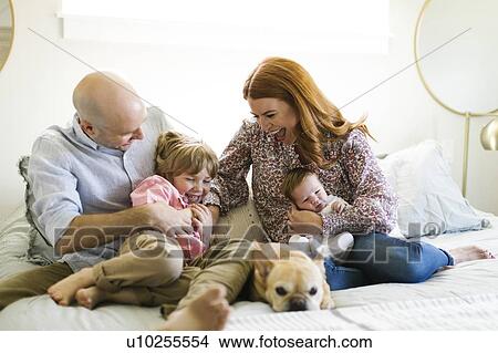 Family and their dog on bed View Large Photo Image Picture - Family and their dog on bed. Fotosearch