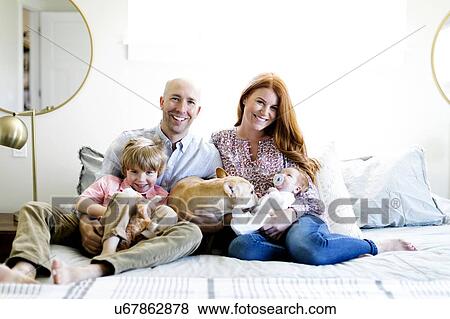 Family and their dog on bed View Large Photo Image Stock Photo - Family and their dog on bed. Fotosearch