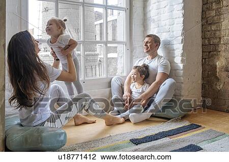 Stock Image - Family sitting by window. Fotosearch