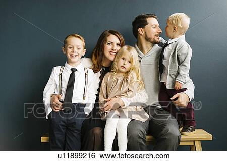Stock Photograph - Family sitting on bench. Fotosearch