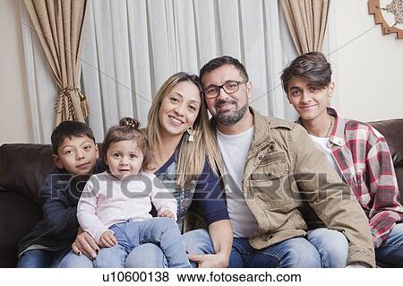 Stock Photo - Family sitting on sofa. Fotosearch