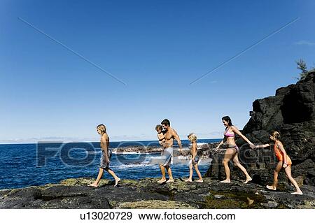 Family walking on rocks by sea View Large Photo Image Stock Photo - Family walking on rocks by sea. Fotosearch