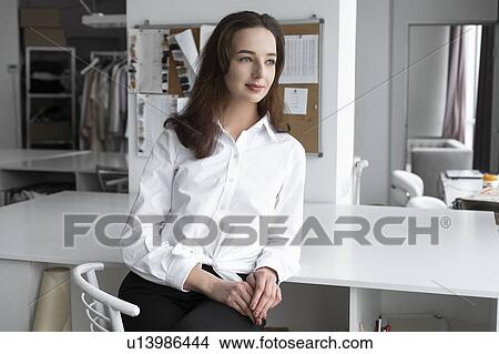 Fashion designer sitting at desk View Large Photo Image Picture - Fashion designer sitting at desk. Fotosearch