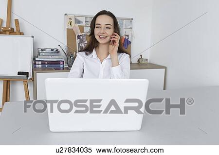 Stock Photography - Fashion designer talking on smart phone. Fotosearch