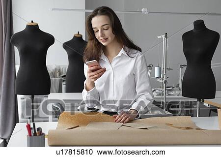 Fashion designer using smartphone in studio View Large Photo Image Stock Image - Fashion designer using smartphone in studio. Fotosearch