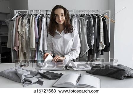 Stock Photo - Fashion designer with portfolio in studio. Fotosearch