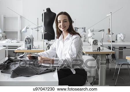 Stock Image - Fashion designer working in studio. Fotosearch