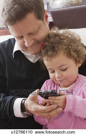 Father and daughter using smart phone View Large Photo Image Stock Image - Father and daughter using smart phone. Fotosearch