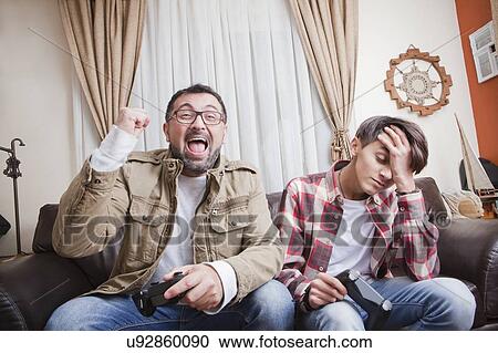 Father and son playing video game View Large Photo Image Stock Image - Father and son playing video game. Fotosearch