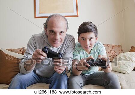 Father and teenage son playing video game View Large Photo Image Stock Photo - Father and teenage son playing video game. Fotosearch