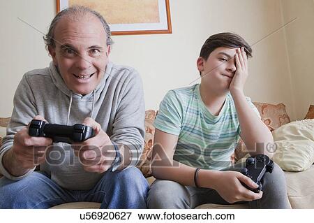 Father and teenage son playing video game View Large Photo Image Stock Photo - Father and teenage son playing video game. Fotosearch