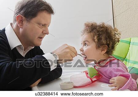 Father feeding his daughter View Large Photo Image Picture - Father feeding his daughter. Fotosearch