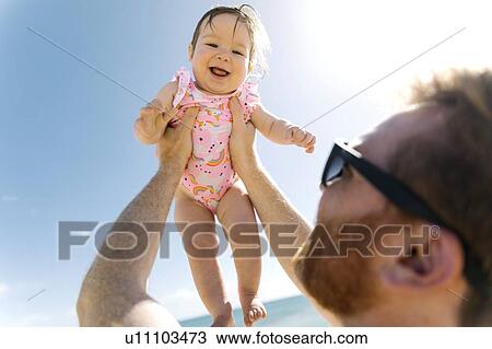 Father holding his baby girl aloft View Large Photo Image Stock Image - Father holding his baby girl aloft. Fotosearch