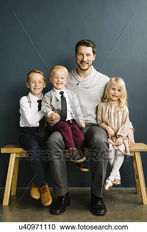 Father sitting with his three children View Large Photo Image Stock Image - Father sitting with his three children. Fotosearch