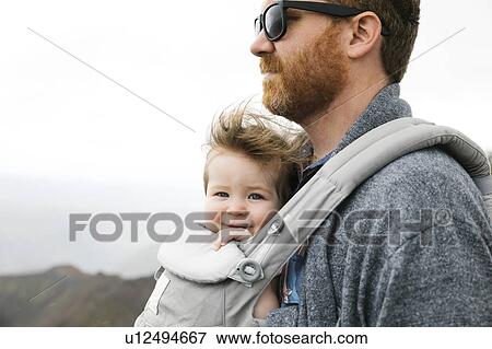 Stock Photo - Father with his baby girl in baby carrier. Fotosearch