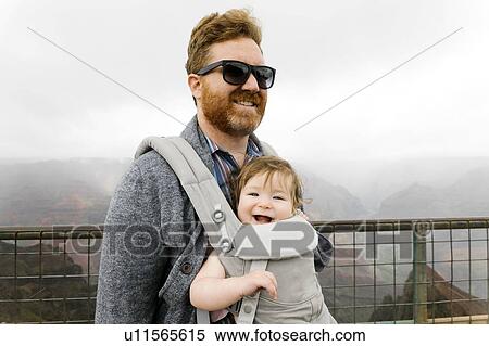 Stock Photography - Father with his baby girl in baby carrier. Fotosearch