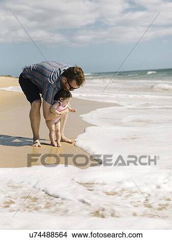 Picture - Father with his baby girl on beach. Fotosearch