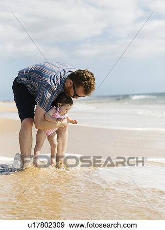 Stock Photo - Father with his baby girl on beach. Fotosearch