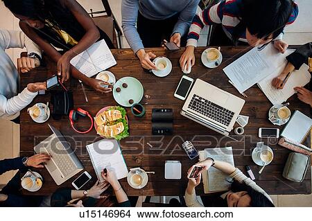 Picture - Female and male business team meeting at cafe table, overhead view. Fotosearch