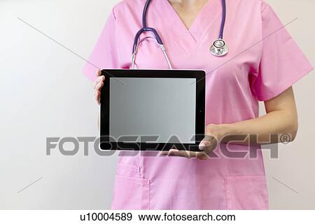 Stock Photo - Female nurse holding digital tablet.. Fotosearch