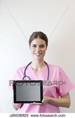 Stock Photography - Female nurse holding digital tablet.. Fotosearch