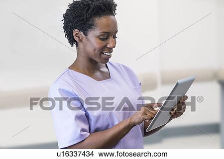 Picture - Female nurse using digital tablet.. Fotosearch