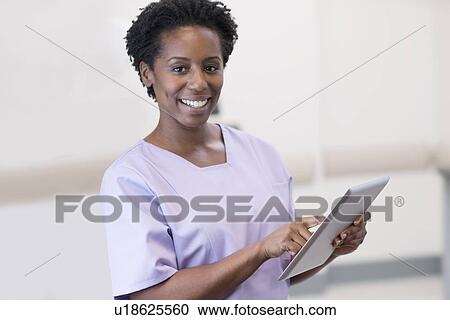 Stock Image - Female nurse using digital tablet.. Fotosearch