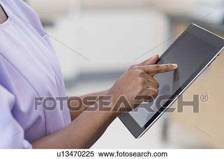 Stock Photography - Female nurse using digital tablet.. Fotosearch