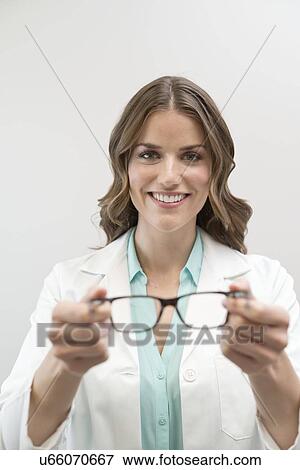 Female optician holding glasses. View Large Photo Image Stock Photo - Female optician holding glasses.. Fotosearch