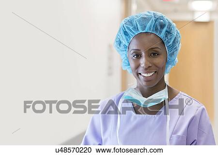 Stock Image - Female surgeon looking towards camera, portrait.. Fotosearch