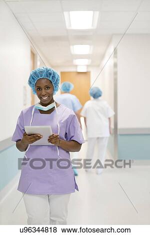 Stock Photo - Female surgeon using digital tablet in hospital.. Fotosearch