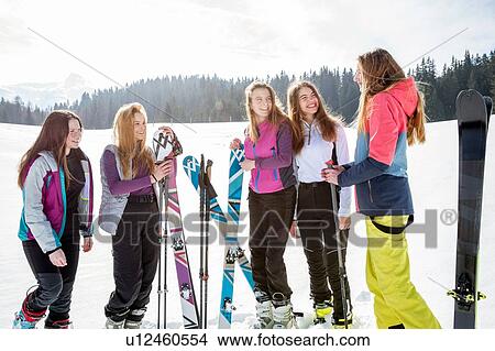 Picture - Five teenage girl skiers chatting in snow covered landscape, Tyrol, Styria, Austria. Fotosearch