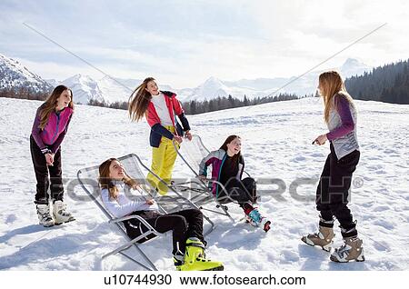 Five teenage girl skiers standing and in deck chairs in snow covered landscape, Tyrol, Styria, Austria View Large Photo Image Stock Image - Five teenage girl skiers standing and in deck chairs in snow covered landscape, Tyrol, Styria, Austria. Fotosearch