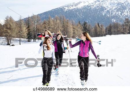 Stock Photo - Five teenage girl skiers walking in snow covered landscape, Tyrol, Styria, Austria. Fotosearch