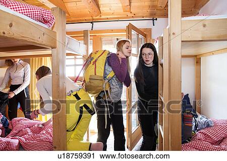 Stock Image - Four teenage girl skiers getting ready in cabin. Fotosearch